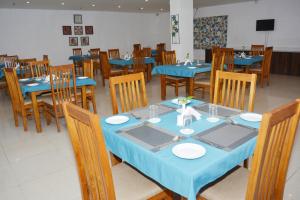 a dining room with blue tables and wooden chairs at Hotel Golden Anchor Dhamara in Dhāmara