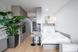a bedroom with a white bed and a plant at Work&Living Studio-Prístavná1 in Nivy