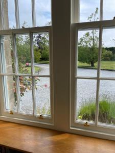 une pièce avec trois fenêtres donnant sur un jardin dans l'établissement Coachman's at Claremont Cottage, à St Andrews