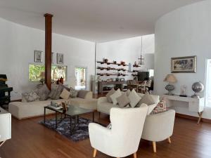 a living room with a couch and a table and chairs at Tropical Garden Luxury Villa, Koh Phangan in Koh Phangan