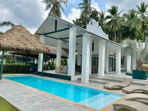 a villa with a swimming pool and palm trees at Tropical Garden Luxury Villa, Koh Phangan in Koh Phangan