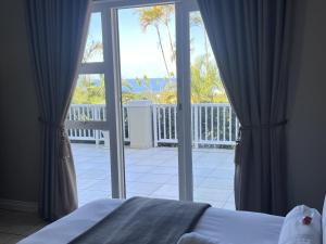 a bedroom with a bed and a sliding glass door at Seaview Manor Exquisite Bed & Breakfast in Durban +121 photos