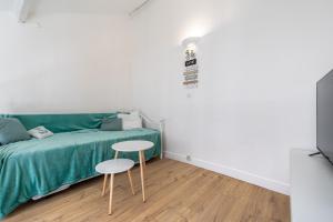 a bedroom with a green bed and a table at Duplex cosy centre historique in Limoges