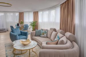a living room with a couch and two chairs at Lotus Therme Hotel & Spa in Hévíz