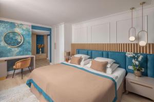 a bedroom with a large bed with a blue headboard at Lotus Therme Hotel & Spa in Hévíz