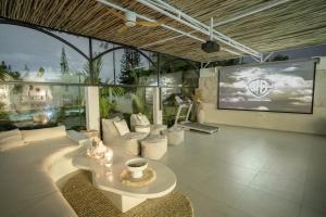 un salon avec un canapé et une télévision dans l'établissement Villa Nair NEW stylish 3BR Canggu with large pool, projector & green field view, à Canggu