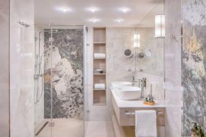 a bathroom with a shower and a sink and a mirror at Lotus Therme Hotel & Spa in Hévíz +60 photos