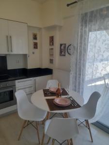 a kitchen with a white table and white chairs at Anesis Premium Living in Ioannina +18 photos