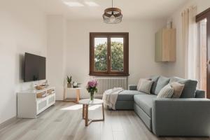 uma sala de estar com um sofá azul e uma TV em Casa Ferrant em Faloppio