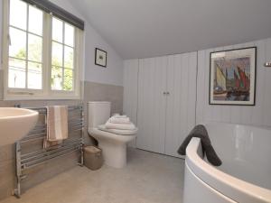 a bathroom with a tub and a toilet and a sink at 3 Bed in Bothenhampton DC160 in Bridport +20 photos