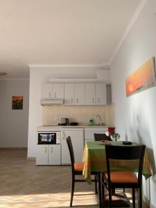 a kitchen with a table and chairs and a kitchen with white cabinets at Dilina Studios in Arkasa