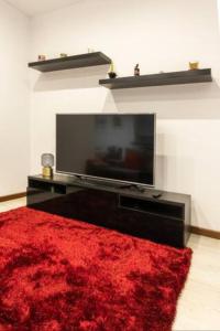 sala de estar con TV de pantalla plana y alfombra roja en LEÇA'S BEACH FLAT**AMAZING VIEWS**PORTO, en Leça da Palmeira