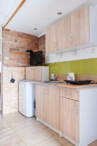 uma cozinha com armários de madeira e um frigorífico branco em Pura Vida em Zaječí