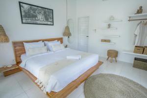 une chambre blanche avec un grand lit dans une pièce dans l'établissement Villa Nair NEW stylish 3BR Canggu with large pool, projector & green field view, à Canggu
