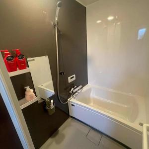 a bathroom with a shower and a sink and a tub at OSAKA FUJI STAY namba in Osaka