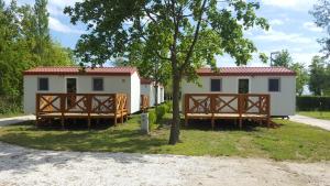 a house with a gate and a tree at Badacsony Camping in Badacsonytomaj