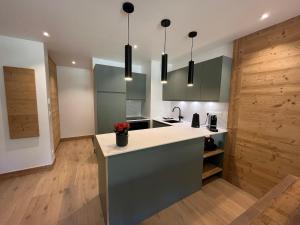 cocina con armarios verdes y encimera en Ski In-Ski Out Luxe Chalet Apartment in Arc 1950 - Newly Renovated, en Arc 1950