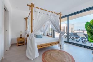 a bedroom with a canopy bed and a balcony at Dino Villa with ocean view in Casal do Cigano