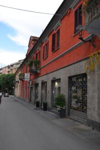 an empty city street with a red building with plants at Apartment Alfieri in Alba