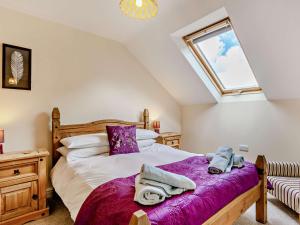 Un dormitorio con una cama con sábanas moradas y una ventana. en 3 Bed in Woolsery LABBA, en Woolfardisworthy