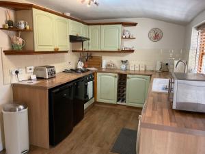 a kitchen with green cabinets and a counter top at Lark Cottage in Pickering