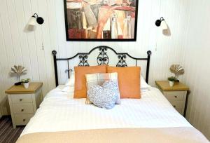 a bedroom with a bed with orange pillows at Beech Lodge 1 Hot Tub in York