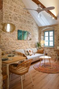 un soggiorno con un divano e un tavolo di "Historic Stone Loft" - ZF Stari Grad a Stari Grad (Cittavecchia)