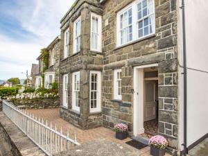 a stone house with white windows and a white fence at 6 Bed in Harlech 89630 in Harlech