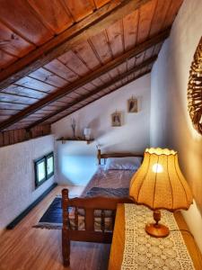 a bedroom with a bed and a lamp on a table at Relaxing Historic House on the Adriatic coast in Lukovo