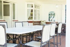 an empty patio with white tables and chairs at Forest Cottage in Pennington