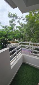 a balcony with a white railing and green grass at Cozy 2BHK with Balcony & Kitchen in Nagpur