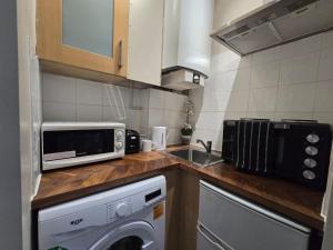 a small kitchen with a microwave and a dishwasher at Piccadilly West End Studio in London