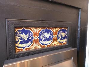 a fireplace with a blue and white tile on it at Piccadilly West End Studio in London