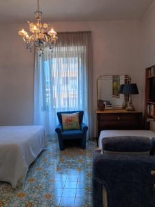 una camera con due letti, una sedia e un lampadario a braccio di Room with a view a Salerno