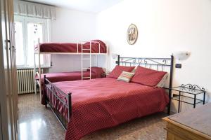 a bedroom with two bunk beds with red sheets at En&Gi Holiday Home in Villa Rossi