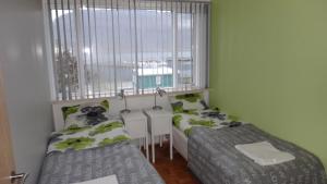 a small bedroom with two beds and a window at Fjord Guesthouse in Súðavík