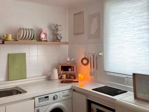 a kitchen with a washing machine and a window at Song-i stay & in Seoul +30 photos