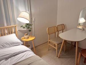 a bedroom with a bed and a table and chairs at Song-i stay & in Seoul