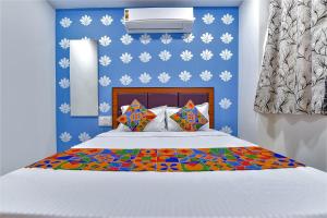 a bedroom with a bed with a blue wall at FabHotel Green Park in Ahmedabad