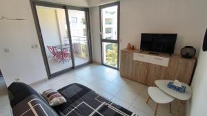 a living room with a couch and a tv at Côté Port in La Ciotat