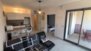 a living room with a couch and a kitchen at Côté Port in La Ciotat