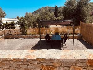a table and chairs under an umbrella in a yard at Almyrolithos in Gythio