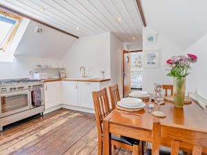 a kitchen with a wooden table with chairs and a wooden floor at 1 Bed in New Quay 45927 in New Quay +7 photos