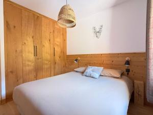 a bedroom with a white bed with wooden walls at Pierra néva, Terrasse et confort 4 étoiles in Champagny-en-Vanoise