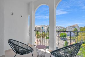 a balcony with two chairs and a view of a city at Exclusive Double Room in Occidental Puerto Banus by Finest Rentals in Marbella