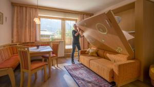 a woman standing in a living room with a couch at Sonnenappartement in Mayrhofen