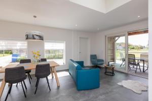 a dining room and living room with a table and chairs at Welcome in - Vakantiewoning Jikkemien met terras, vrij uitzicht en huisdiervriendelijk in Koudekerke