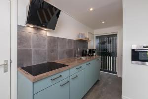 a kitchen with a sink and a stove at Welcome in - Vakantiewoning Jikkemien met terras, vrij uitzicht en huisdiervriendelijk in Koudekerke +19 photos