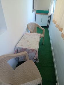 2 sillas y una mesa en una habitación con alfombra verde en Apartament 3 cam Portul Turistic Mangalia, en Mangalia 5 fotos más