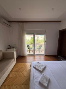 a bedroom with a bed and a couch and a patio at Casa Sinani in Ulcinj